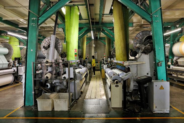 高阳已成为国内最大的纺织品制造基地.图为工人在车间监控设备.